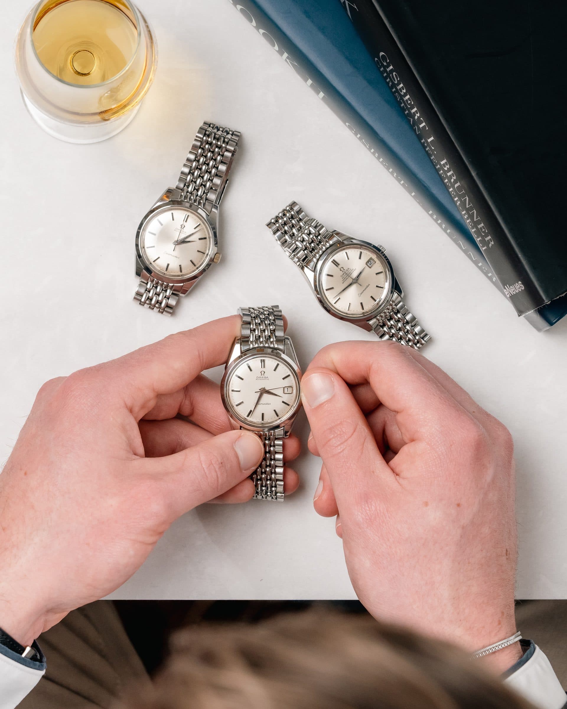 Two hands holding two vintage watches